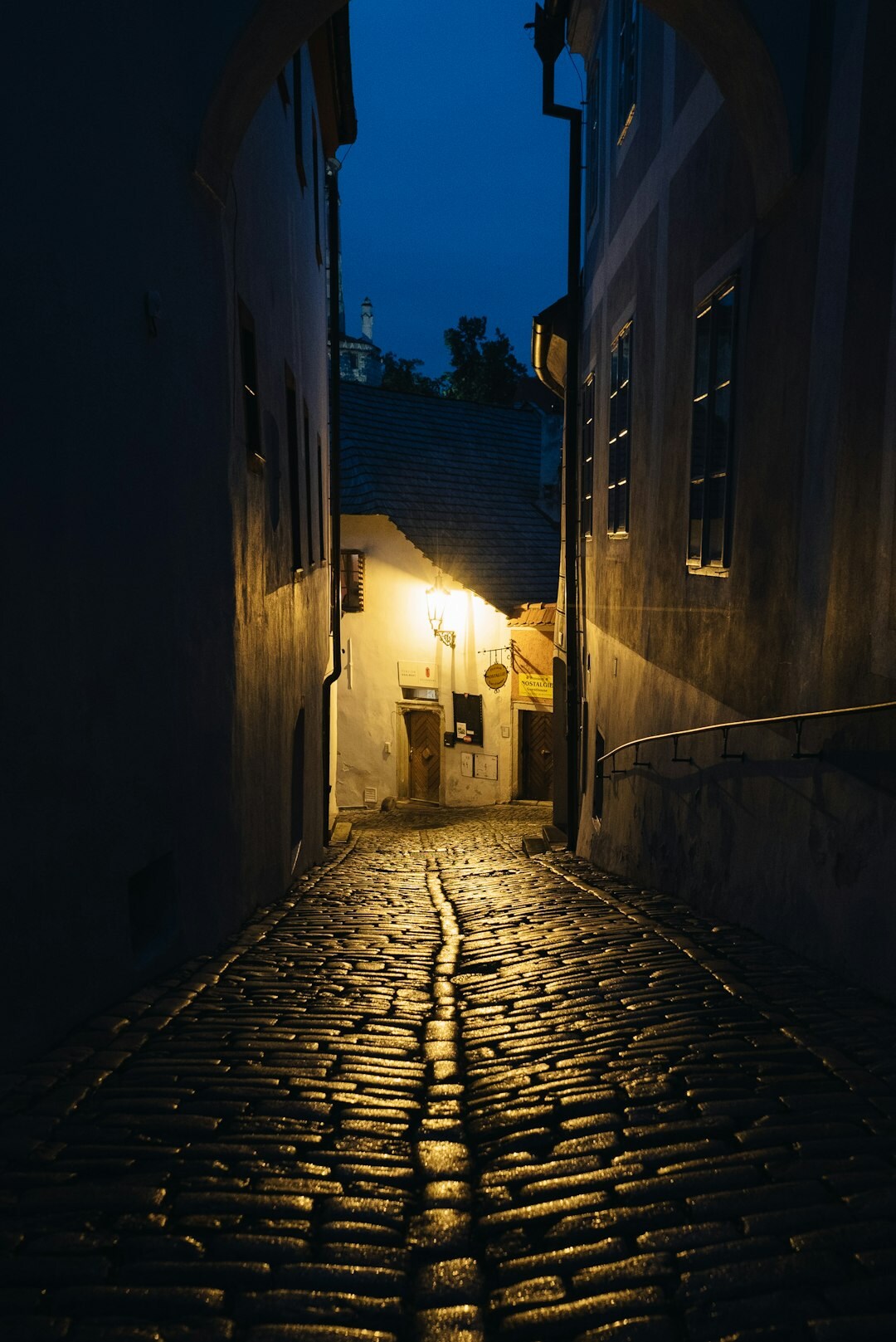 Foggy cobblestone alley in an old European town at night